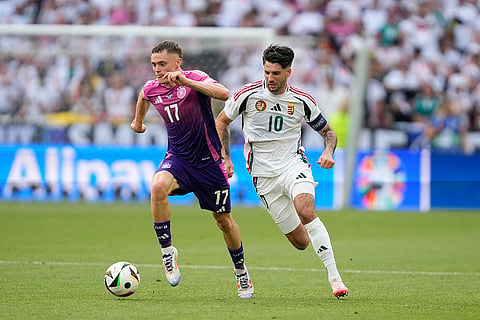 Florian Wirtz dribbles past Dominik Szoboszlai